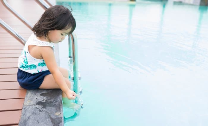 Girl by side of swimming pool