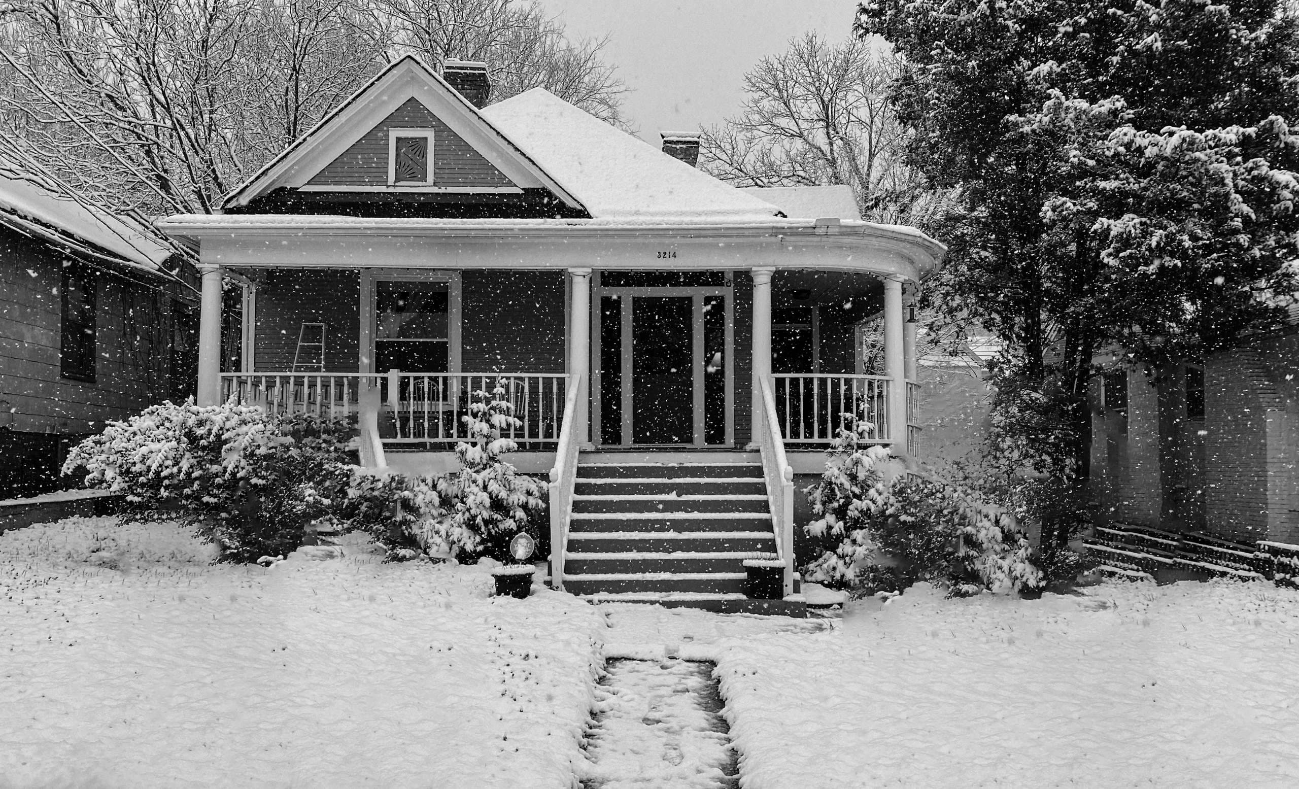 House in winter with snow around it. Property damage in winter.